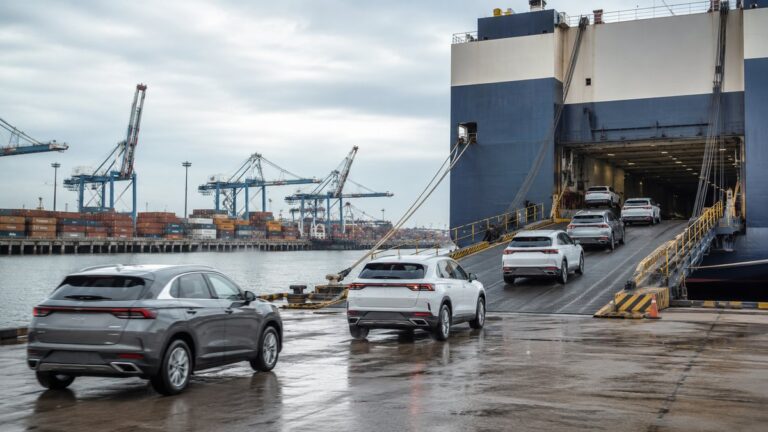Cars driving onto a roll-on roll-off ship at a port for international shipping