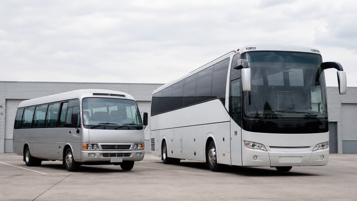Minibus and full-size charter coach parked side by side for a size comparison
